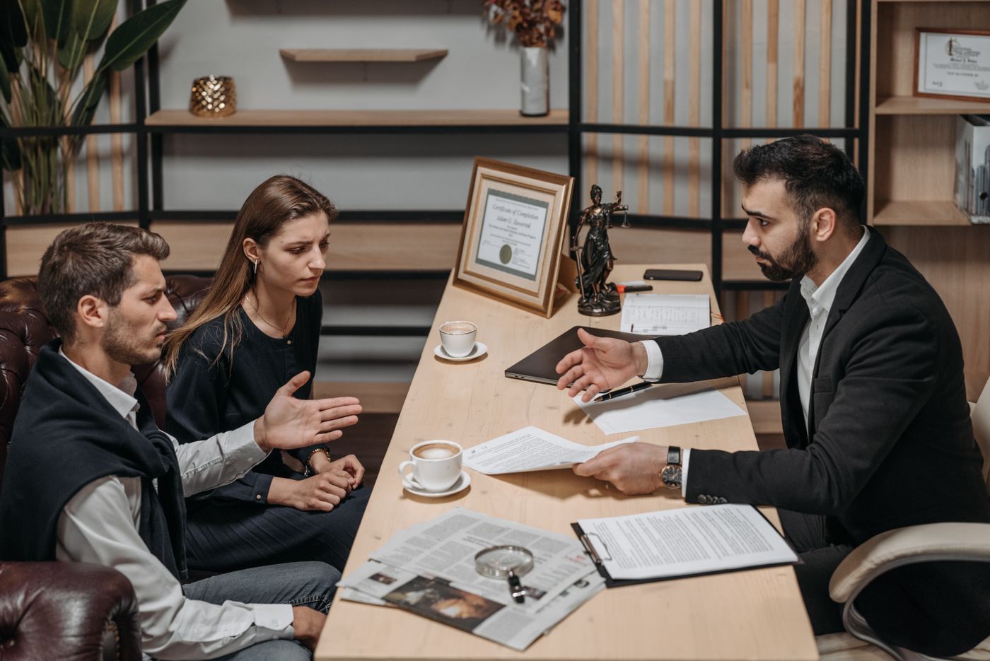 A lawyer and clients discussing paperwork together in an office